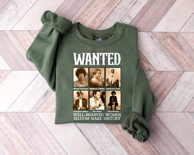 May include: Green sweatshirt with a white print that says "WANTED" and features black and white photos of six women. The text below the photos says "WELL-BEHAVED WOMEN SELDOM MAKE HISTORY."