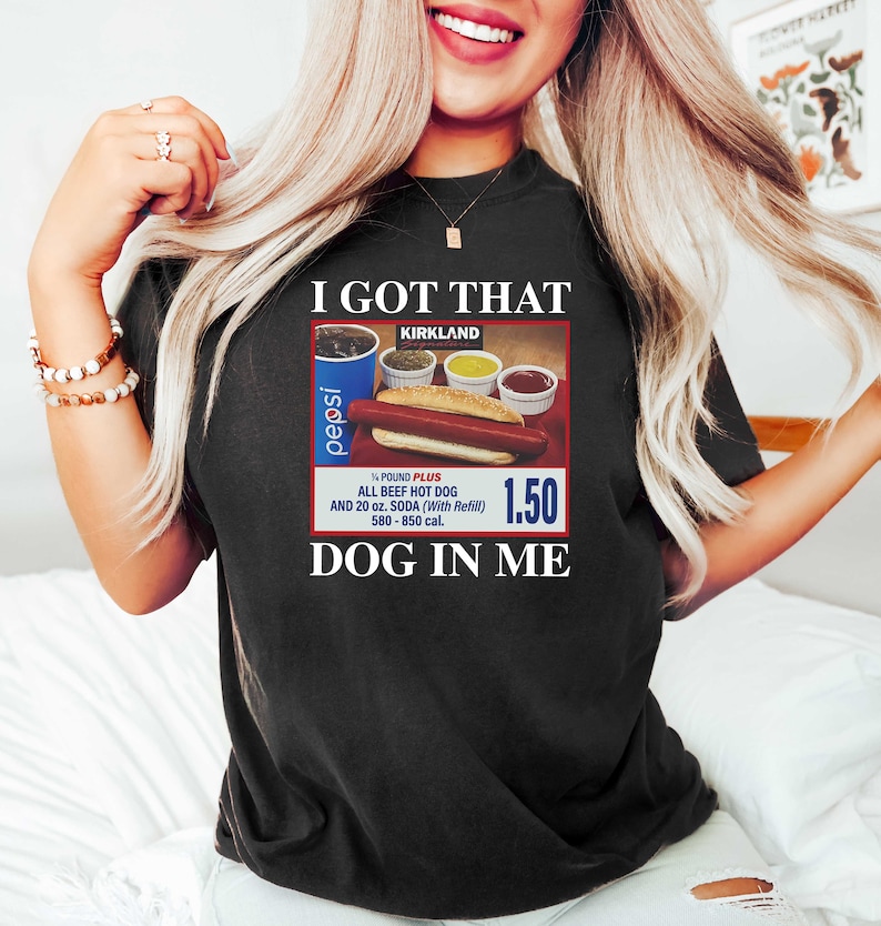 May include: A black t-shirt with the text "I GOT THAT KIRKLAND" and a picture of a hot dog meal with a Pepsi, a hot dog, and condiments. The text "1.50" and "DOG IN ME" are also on the shirt.