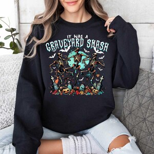 May include: Black sweatshirt with a graphic of three skeletons dancing with the text "It was a graveyard smash".