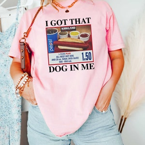 May include: Pink t-shirt with a graphic of a hot dog, soda, and condiments with the text "I got that dog in me" and "Kirkland" on it.
