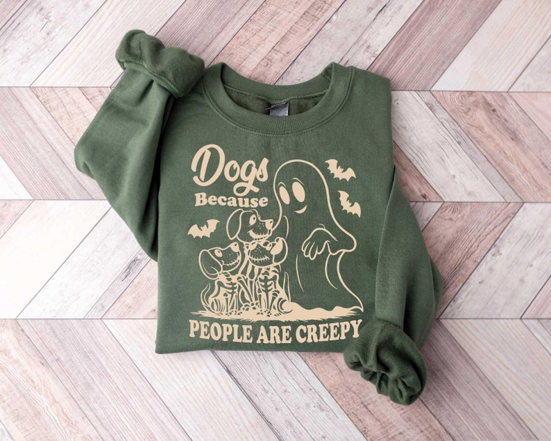 Puede incluir: Sudadera verde con un fantasma y perros esqueleto. El texto dice "Dogs Because People Are Creepy".