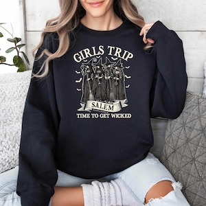 May include: Black sweatshirt with a graphic of witches and the text "Girls Trip Salem Time to Get Wicked".