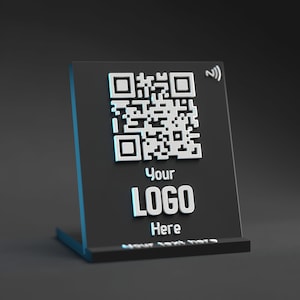以下が含まれることがあります： 白いQRコード、テキスト「Your LOGO Here」、Bluetoothシンボルが書かれた黒いアクリルスタンド