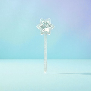 May include: A transparent star-shaped wand with a textured centre and a long, slender handle. The wand is set against a gradient blue background, creating a whimsical and magical aesthetic.