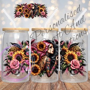 May include: Three clear glass jars with wooden lids and straws. Each jar features a colourful design of a woman with tattoos, sunflowers, leopard print, and pink feathers. The jars are ideal for holding drinks.