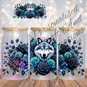 May include: Three clear glass tumblers with wooden lids and straws. Each tumbler features a design of a wolf's head surrounded by blue and black roses.