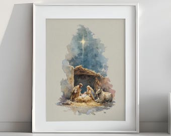 May include: Watercolor print of the Nativity scene, framed in white. The artwork depicts the Holy Family in a stable, with a bright star shining above. The color palette includes soft blues, browns, and yellows, creating a serene and peaceful atmosphere.