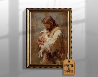 May include: Framed art print depicting a person with long hair holding a lamb. The artwork features warm tones of brown, beige, and white. The frame is gold with a textured border. A tag that says "PRINTED & SHIPPED" is attached.