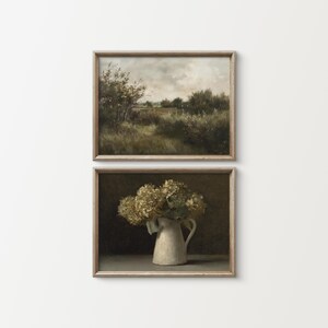May include: Two framed art prints. The top print shows a landscape with trees under a cloudy sky. The bottom print depicts a white jug with dried flowers. Both prints have wooden frames, suitable for a living room or bedroom.