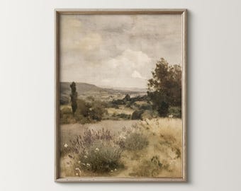 May include: A framed landscape painting depicts a serene countryside scene. The artwork features a field of lavender and tall grasses, with trees and rolling hills in the background. The sky is overcast with soft, muted tones, creating a vintage aesthetic.