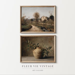 May include: Two framed vintage art prints. The top print shows a rural landscape with a track leading to a building. The bottom print depicts a ceramic vase with olive branches. The prints are from the Fleur Vie Vintage Art Gallery.