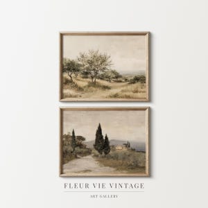Può includere: Due dipinti di paesaggi incorniciati. Il dipinto superiore raffigura alberi in un campo, e il dipinto inferiore mostra una strada che conduce a un edificio. Le cornici sono di colore marrone chiaro. Il testo "FLEUR VIE VINTAGE ART GALLERY" è in basso.