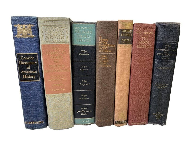 May include: A collection of vintage books with various titles and colors. The spines display titles such as "Concise Dictionary of American History," "The Complete Pelican Shakespeare," and "Cases on Criminal Law and Procedure."