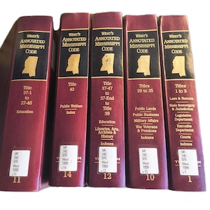 May include: A collection of five burgundy-colored law books titled "West's Annotated Mississippi Code." Each book features gold lettering and a gold outline of the state of Mississippi. The books cover various legal topics and titles.