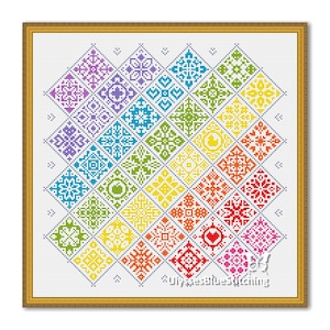 May include: A framed cross-stitch artwork with a geometric design of colourful diamond shapes. Each diamond features a unique pattern in shades of purple, blue, green, yellow, orange, and red. The artwork is set against a white background.