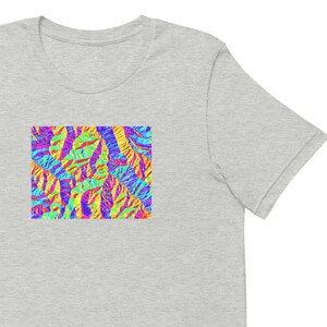 May include: A gray t-shirt with a colorful abstract design featuring a pattern of overlapping shapes in shades of blue, green, yellow, red, and purple.