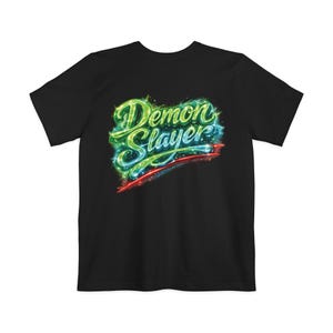 Op de afbeelding: Zwart T-shirt met de tekst "Demon Slayer" in een neon-achtig ontwerp. De tekst is voornamelijk groen en blauw, met rode accenten. Het ontwerp heeft een gloeiend effect.