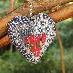 Llavero acolchado con forma de corazón de tela reciclada desgastada. Arte textil de costura lenta.