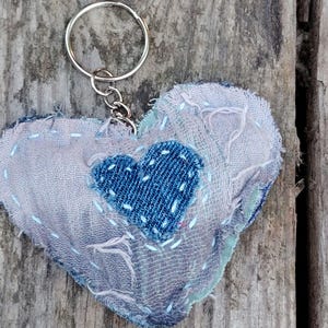 Llavero acolchado de tela desgastada con forma de corazón y motivo de corazón vaquero. Arte textil de costura lenta hecho con textiles reciclados.