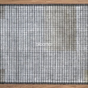 May include: Rectangular rug with a vertical striped pattern in shades of gray and black. The rug has a textured appearance and a dark border. The rug is placed on a wooden floor.