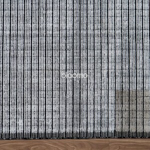 May include: A rectangular rug with a pattern of vertical black stripes on a white background. The rug is made of a textured material and is placed on a wooden floor. The rug's design is simple and modern.