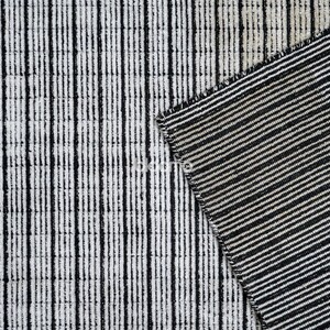 May include: Close-up of a textured fabric with a black and white striped pattern. The fabric is divided into two sections, one with vertical stripes and the other with diagonal stripes. The design is simple and modern, suitable for home decor.