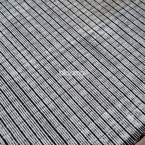May include: A black and white striped rug with a textured surface. The rug features a pattern of diagonal lines, creating a modern and minimalist design. The rug is made of a durable material and is suitable for high-traffic areas.