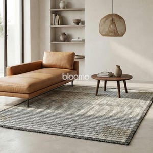 May include: A modern living room scene featuring a tan leather chaise lounge, a round wooden coffee table, and a patterned rug. A woven pendant light hangs above the table. Neutral tones and natural light create a serene atmosphere. Decorative vases and books are on display.