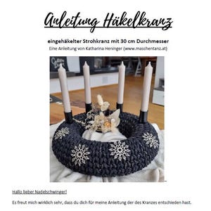 May include: A dark blue crocheted wreath with silver accents and snowflake decorations, holding four white candles. The wreath has a diameter of 30 cm. Text at the top reads "Anleitung Häkelkranz".