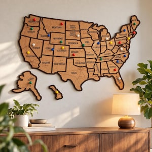 May include: A large cork map of the United States featuring individual state outlines, black borders, and state names printed in black. The map includes separate cutouts for Alaska and Hawaii, decorated with colorful push pins in each state.