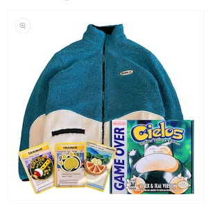 May include: A teal and black sherpa jacket with a white trim. The jacket has a zipper closure and a small logo patch on the left chest. The jacket is displayed on a white background with a game cartridge and three Pokemon cards.