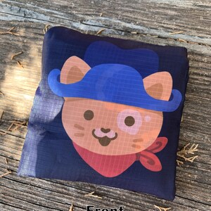 May include: A blue and brown reusable shopping bag with a cartoon cat wearing a blue hat and red bandana. The bag has the word "Front" printed on it.