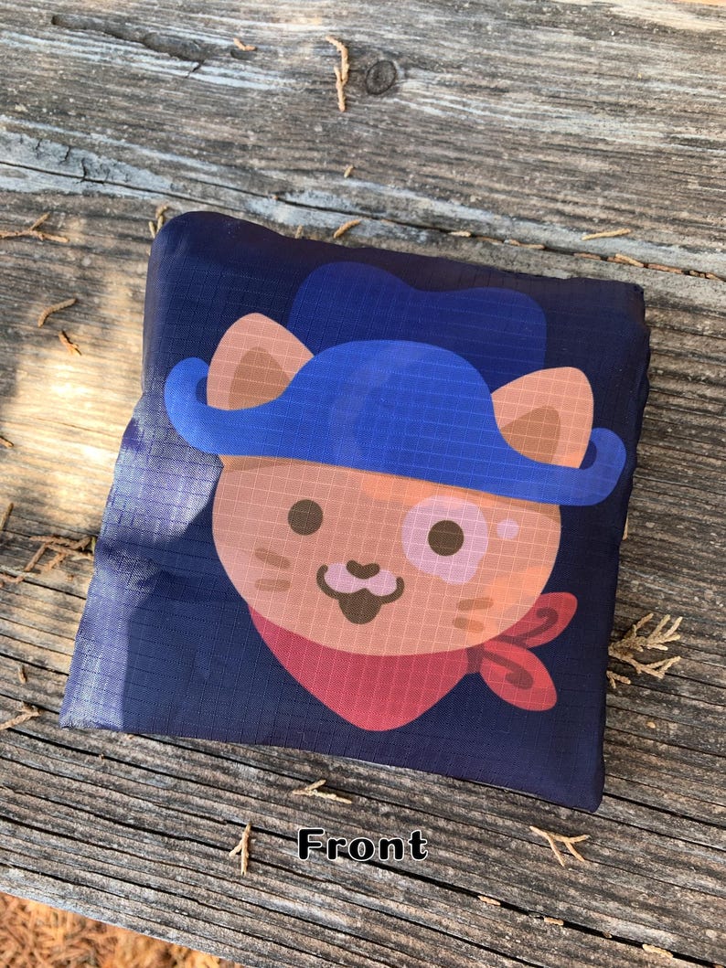 May include: A blue and brown reusable shopping bag with a cartoon cat wearing a blue hat and red bandana. The bag has the word "Front" printed on it.