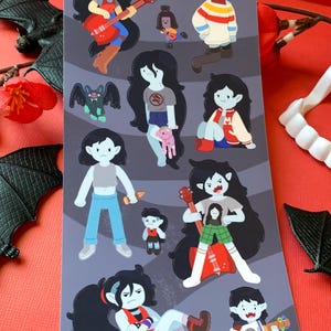 May include: A sheet of stickers featuring a cartoon vampire girl in various poses and outfits. The stickers are on a gray background with a wavy pattern. The girl is wearing a variety of outfits, including a red shirt, a blue shirt, a green shirt, and a pink shirt. She is also wearing a hat, a jacket, and a skirt. The stickers are perfect for adding a touch of whimsy to your laptop, water bottle, or planner.