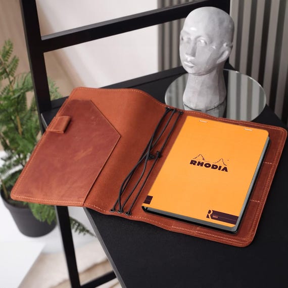 A real leather wrap made specifically to fit a Rhodia notepad — niche, functional, and built for stationery nerds who know exactly what they want.