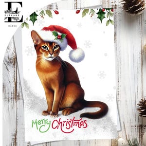 Un chat abyssin, une carte de Noël, un chat coiffé d'un chapeau de Noël. Joyeux Noël. Pour les amoureux des chats de tous âges. Choisissez Pour personnaliser, A5, 6x.