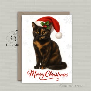 May include: A festive Christmas card showing a tortoiseshell cat wearing a red Santa hat with holly. The words "Merry Christmas" are written in red script. The background is white with snowflake details.