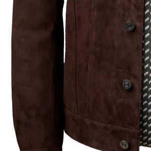 Op de afbeelding: Een bruin su&egrave;de jack met een knoopsluiting en lange mouwen. Het jack heeft een klassieke denim stijl.