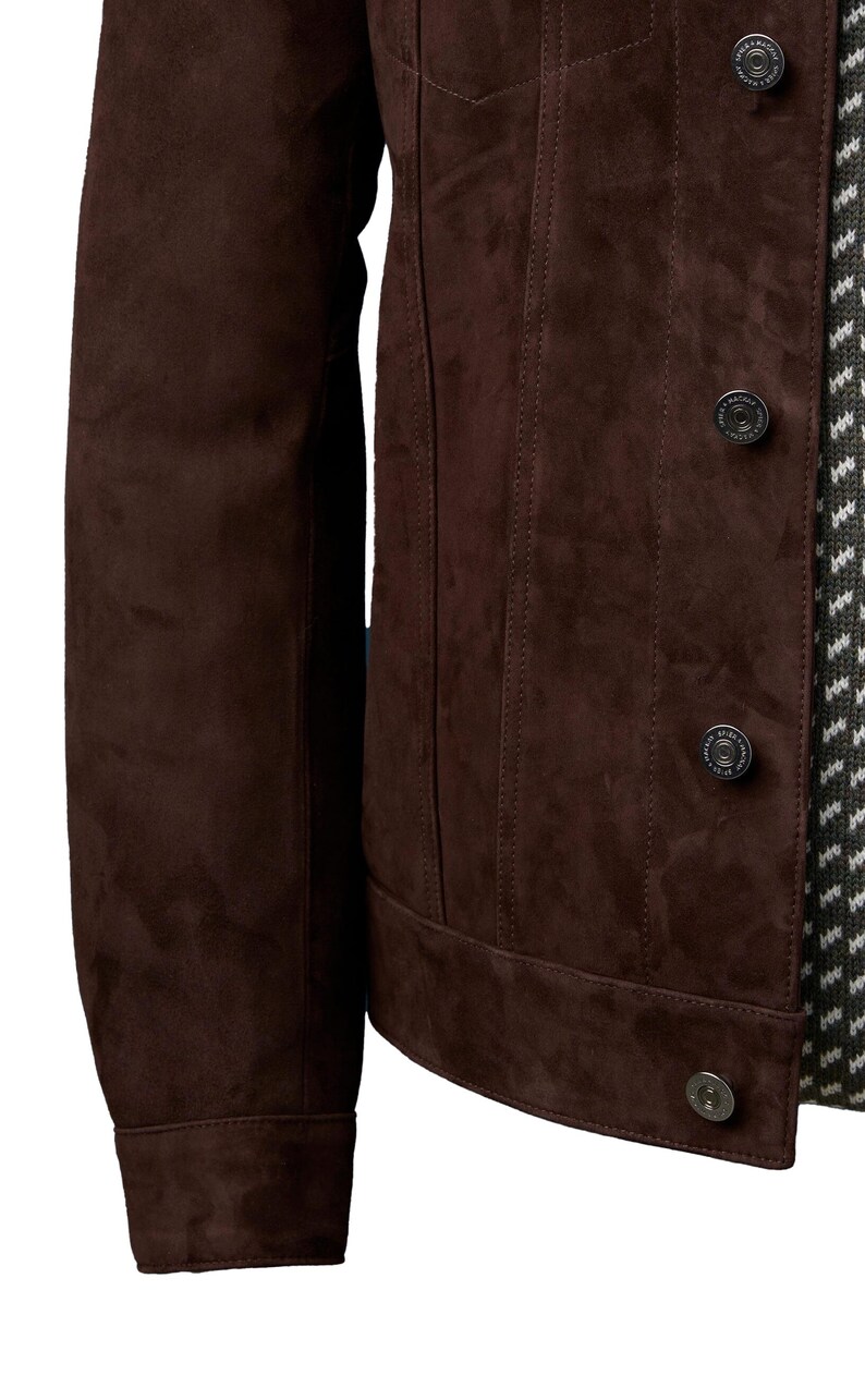 Op de afbeelding: Een bruin su&egrave;de jack met een knoopsluiting en lange mouwen. Het jack heeft een klassieke denim stijl.