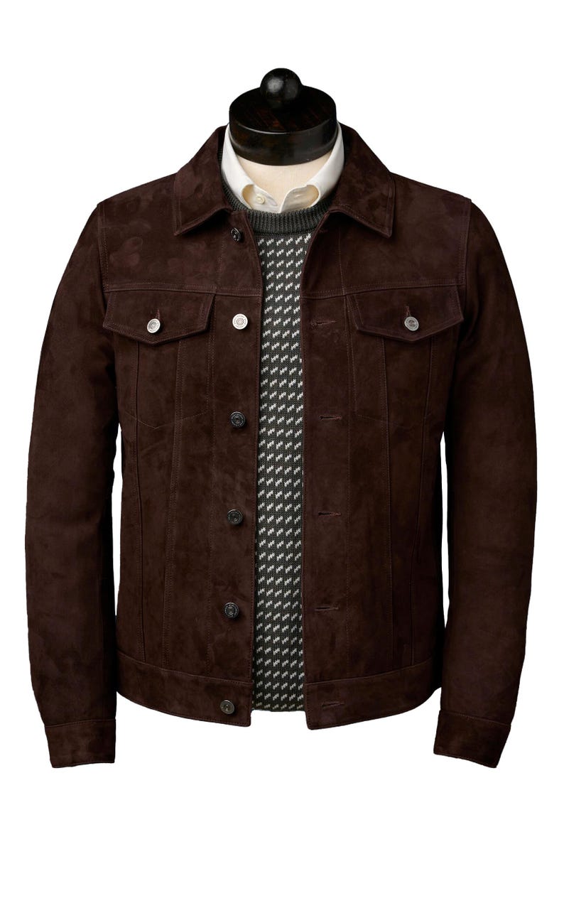 Op de afbeelding: Een bruin su&egrave;de jack met een knoopsluiting en twee klepzakken. Het jack heeft een klassieke denim-stijl.
