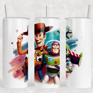 May include: White tumbler with illustrations of Woody and Buzz Lightyear from Toy Story. Woody wears a cowboy hat and Buzz is in a spacesuit. The tumbler has a silver straw and a colourful background.