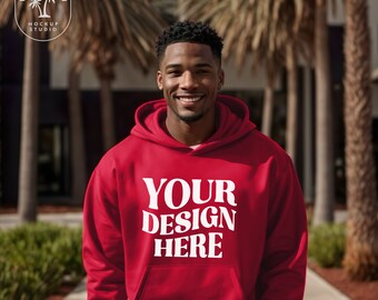 May include: A red hoodie with a white print that says "YOUR DESIGN HERE". The hoodie is being worn by a person with short black hair.