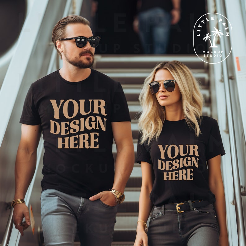 Pode incluir: Duas pessoas vestindo camisetas pretas com o texto "Your Design Here" impresso em marrom na frente. O casal est&aacute; em p&eacute; em uma escada.
