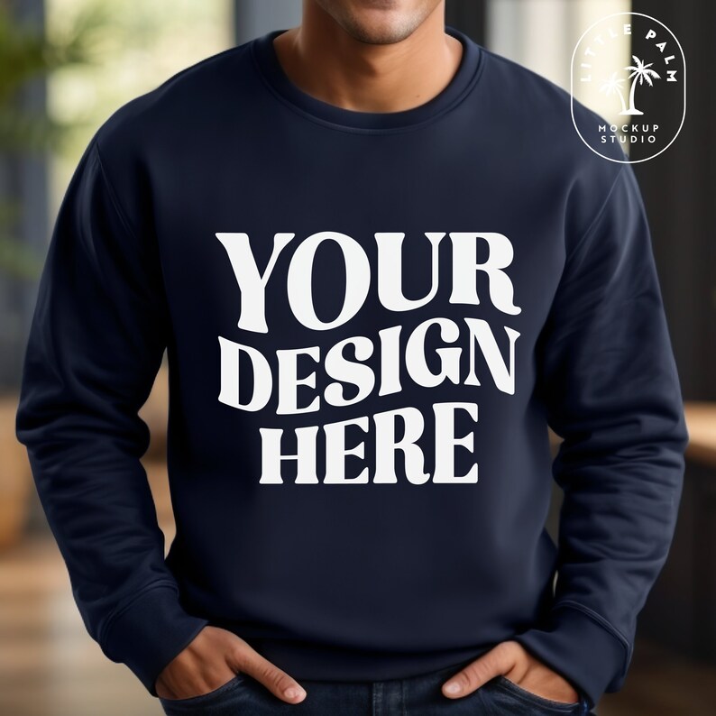 Puede incluir: Una sudadera azul marino con el texto "YOUR DESIGN HERE" en blanco.