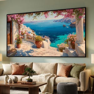May include: A rectangular wall art print depicting a Mediterranean coastal scene with white buildings, a blue sea, and pink bougainvillea flowers framing the view from a stone terrace with terracotta pots and a classical column.