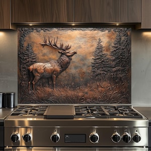 Könnte beinhalten: Ein Edelstahlherd mit einer Kupfer-Rückwand, die ein 3D-geprägtes Bild eines Elchs in einer Waldlandschaft zeigt.