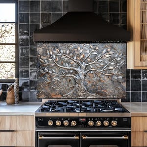 May include: A black and stainless steel gas range with a decorative tree-themed backsplash. The kitchen features light wood cabinetry, black tile, and a black range hood. The range has gold-colored knobs and a double oven.
