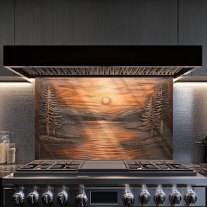 May include: A copper backsplash with a carved design of a sunset over a lake with trees on either side. The backsplash is installed above a stainless steel stove with six burners.