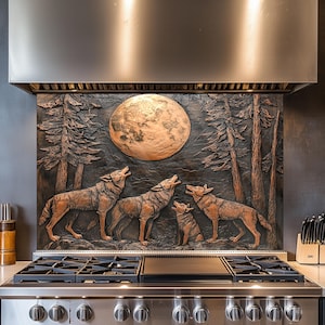 Puede incluir: Un protector contra salpicaduras de metal de color cobre con un diseño 3D de una luna llena y cuatro lobos aullando en un entorno de bosque. El protector contra salpicaduras está instalado sobre una estufa de acero inoxidable con una placa de cocción negra.