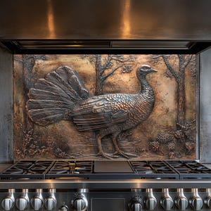Op de afbeelding: Een koperen keukenachterwand met een reliëfdesign van een kalkoen in een bosrijke omgeving. De achterwand is geïnstalleerd boven een roestvrijstalen fornuis met een zwart kookoppervlak.